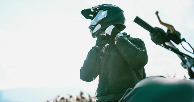 motorcyclist putting on their helmet